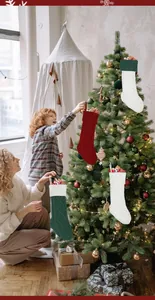 Detail van kabelgebreide kerstkousen in rood, groen en wit hangend aan de kerstboom