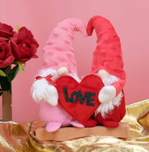 Detail of two Valentine gnomes holding a large red heart with LOVE text in soft plush fabric