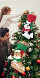 Detailed view of cat and dog Christmas stockings with gift fillers by a Christmas tree