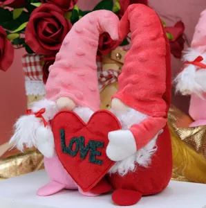 Detail of plush Valentine Gnomes holding a red LOVE heart with rose background