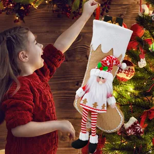 Christmas stocking with plush chef hat gnome hanging on decorated Xmas tree background