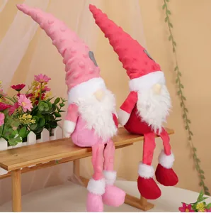 Details von rosa und roten Valentinstag-Wichteln mit Herzmotiven auf einer Holzbank