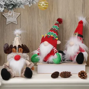 Three Christmas gnomes featuring reindeer antlers and sequined hats on wooden background