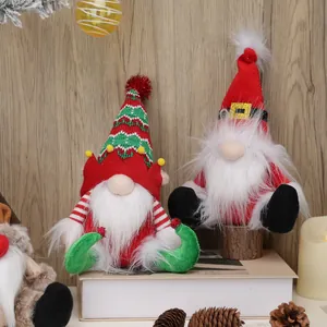 Set of two festive Christmas faceless gnomes with knitted hats on wooden background