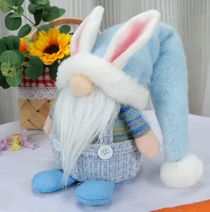 Detail of plush Easter gnome with long bunny ears and blue checkered overalls on white cloth