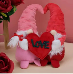Detail of plush Valentine gnomes holding a large red heart with LOVE embroidery