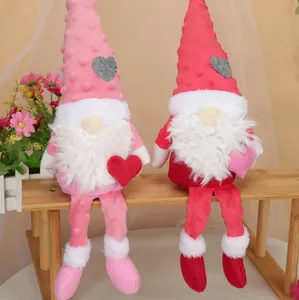 Detail von Plüsch-Valentins-Wichteln mit langen Beinen und Herzen auf einer Holzbank