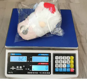 Detailopname van pluche kabouter op weegschaal met productgewicht van 62,1 gram