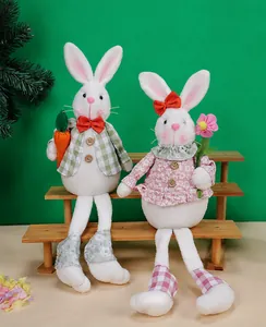 Détail de gnomes lapins de Pâques en peluche avec carotte et fleur sur socle bois