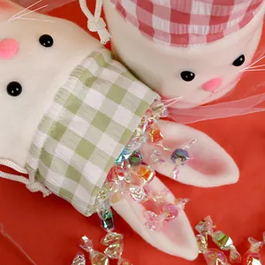 Plush Easter bunny candy bags with red and green plaid trim on a vibrant red background
