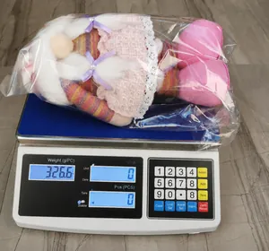 Detailed weight measurement of a cute pink gnome plush doll on a digital scale
