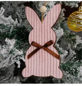 Detail of pink corduroy Easter bunny ornament with bow on a rustic tree branch