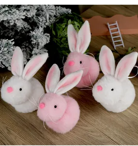 Detailansicht plüschiger Osterhasen-Anhänger in Rosa und Weiß auf einer Holzoberfläche