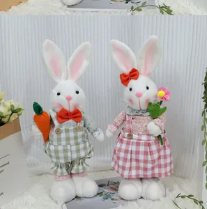 Détail de gnomes lapins de Pâques avec motifs à carreaux tenant carotte et fleur