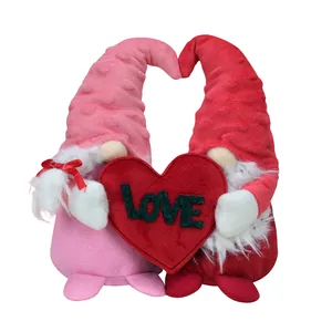 Pair of Valentine's Day plush gnomes holding a red heart with Love lettering on white background