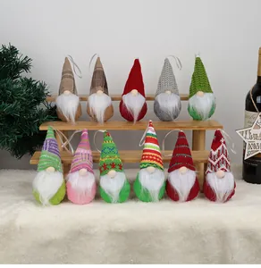 Set di undici gnomi di Natale colorati con cappelli di maglia esposti su scale di legno