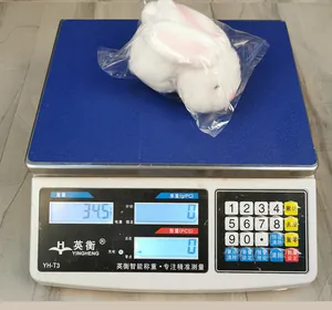 Detailansicht eines weißen Plüschhasen mit einer Gewichtsangabe von 34,5 g auf der Waage
