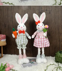 Détail de gnomes lapins de Pâques en peluche avec carotte et fleurs sur fond bois