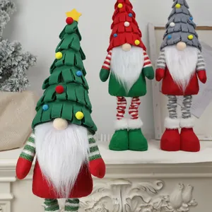 Trois gnomes de Noël avec de longs chapeaux et barbes blanches sur la cheminée
