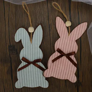 Easter rabbit hanging ornaments with corduroy texture and wooden beads on wood background