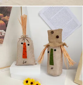 Dettaglio di sacchetti decorativi in iuta con visi di spaventapasseri e accenti di paglia