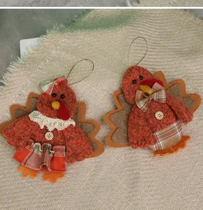 Detailed view of two Thanksgiving turkey plush ornaments with tweed and lace details