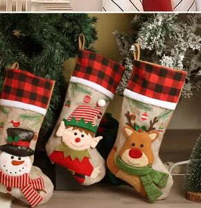 Detail of three Christmas stockings with snowman elf and reindeer hanging decoration