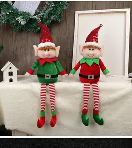 Close-up of Christmas elf dolls with sequin hats and striped legs for home decor