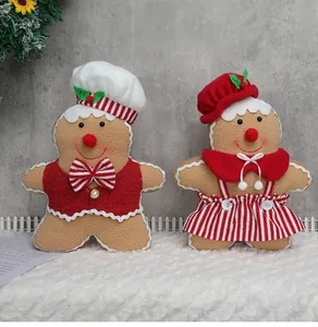 Detail of plush gingerbread couple dolls in festive outfits for Christmas home decoration