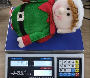 Detail shot of a festive Christmas elf plush doll on a scale showing its weight