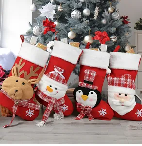 Dettaglio di quattro calze natalizie in peluche con renna, pupazzo di neve e Babbo Natale