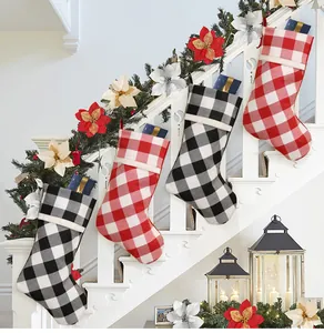 Close-up of four buffalo plaid Christmas stockings hanging on a white staircase railing