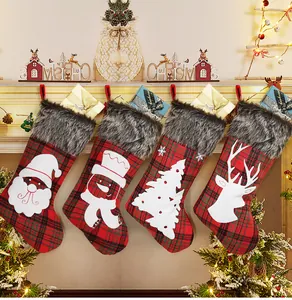 Close-up of four plaid Christmas stockings with white silhouettes hanging on a mantle