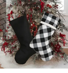 Detail of minimalist black and buffalo plaid Christmas stockings on a festive mantel