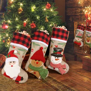 Three Christmas stockings with Santa and Gingerbread Man hanging by a festive tree