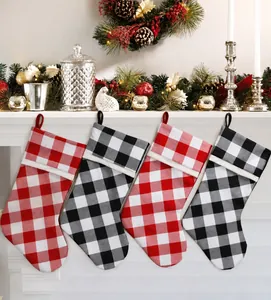 Red and black buffalo plaid Christmas stockings hanging on a cozy festive fireplace