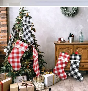 Detail of buffalo plaid Christmas stockings with white faux fur cuffs hanging indoors