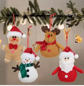Detail van kerstversieringen van pluche met peperkoekman hangend aan een dennentak