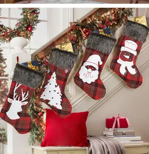 Detailed view of four plaid Christmas stockings hung with gift boxes inside on a staircase