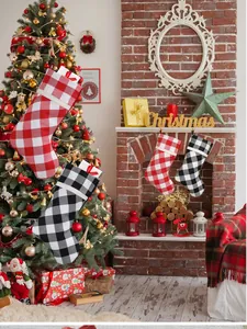 Classic red and black buffalo plaid Christmas stockings hanging on a brick fireplace