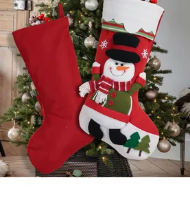 Close-up of snowman applique and red Christmas stockings hanging on a festive tree