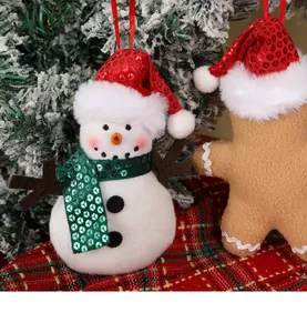Detail van pluche sneeuwpop en gemberkoekpoppetje ornamenten met pailletten in kerstboom