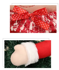 Detail of red Christmas elf tree topper with plush cuffs and polka dot ribbon bow