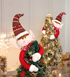 Dettaglio dei folletti di Natale in peluche per l'albero in una calda cornice festiva