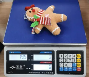 Gingerbread man plush ornament weighing 19.9g on a scale for Christmas decoration