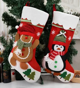 Detail van kerstsokken met 3D-peperkoekmannetje en pinguïnfiguren aan een kerstboom