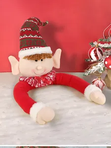 Macro shot of plush Christmas elf tree topper with festive red and green striped knit hat