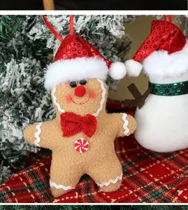Detail van pluche peperkoekman met paillettenhoed en strikje aan de kerstboom hanger