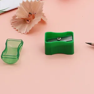 Creative bread-shaped green manual pencil sharpener with transparent cap on pink background