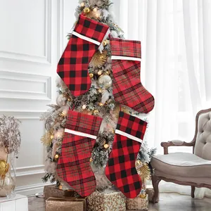 Set of 4 buffalo plaid and Scottish tartan Christmas stockings hanging on a white tree